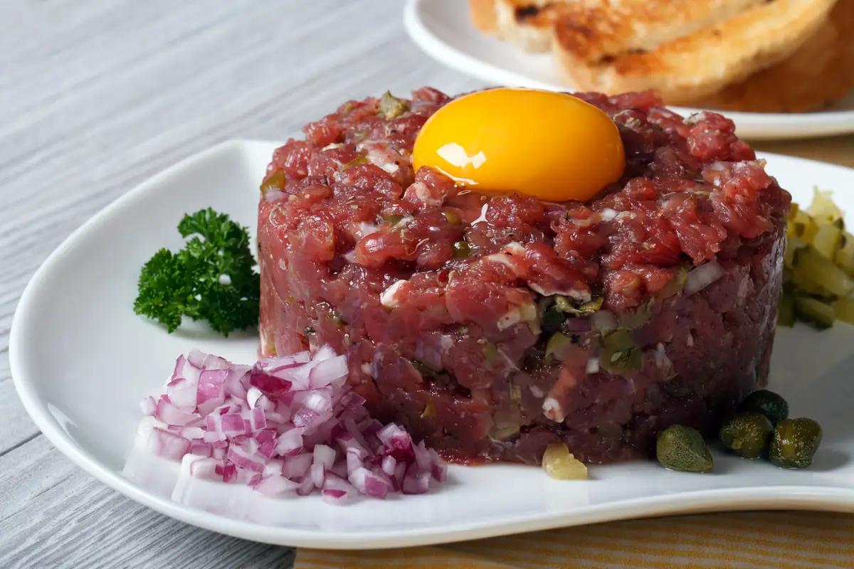 Biftect tartar cu gălbenuș de ou, ceapă și capere.
